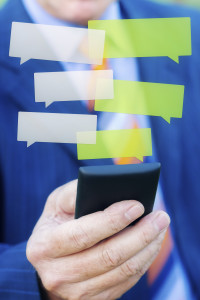 Close up of a man hand typing a message with smartphone, blurred background